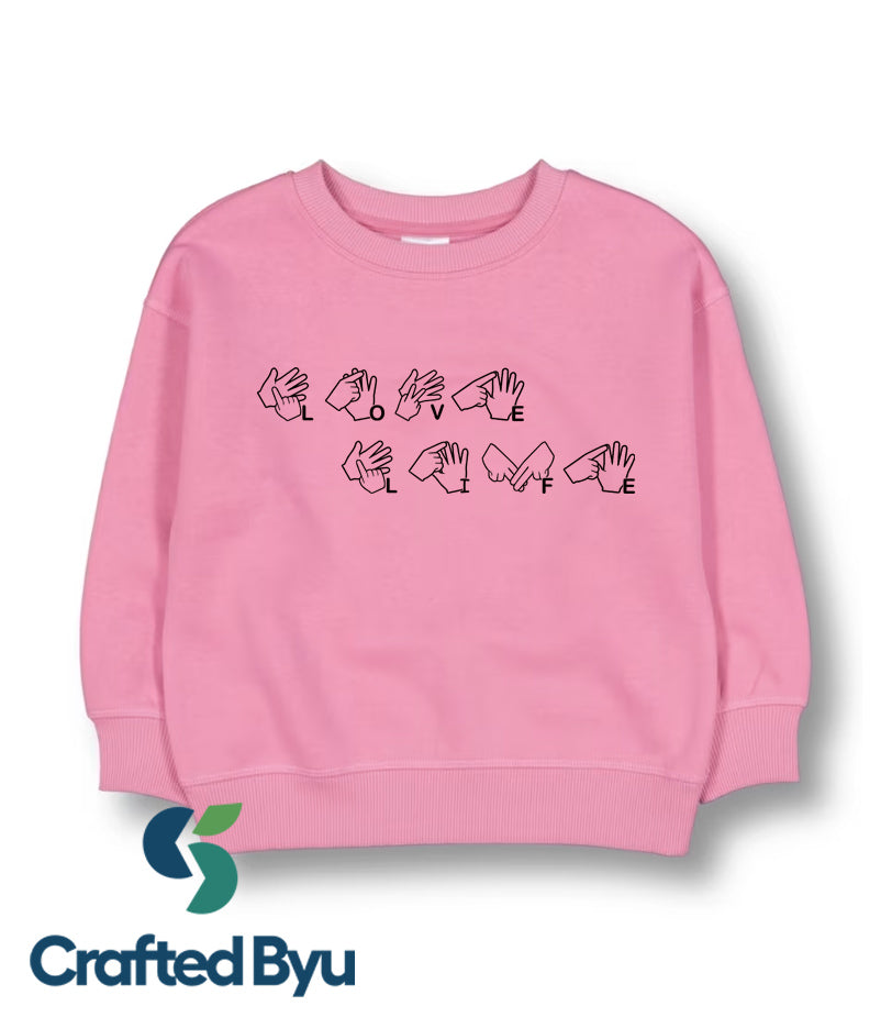 A pink toddler girls fleece sweat top with Auslan sign language characters printed on the front.
